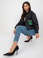 Schwarze gesteppte Jacke mit Knopfverschluss.
