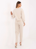 Light beige two-piece set with studs.