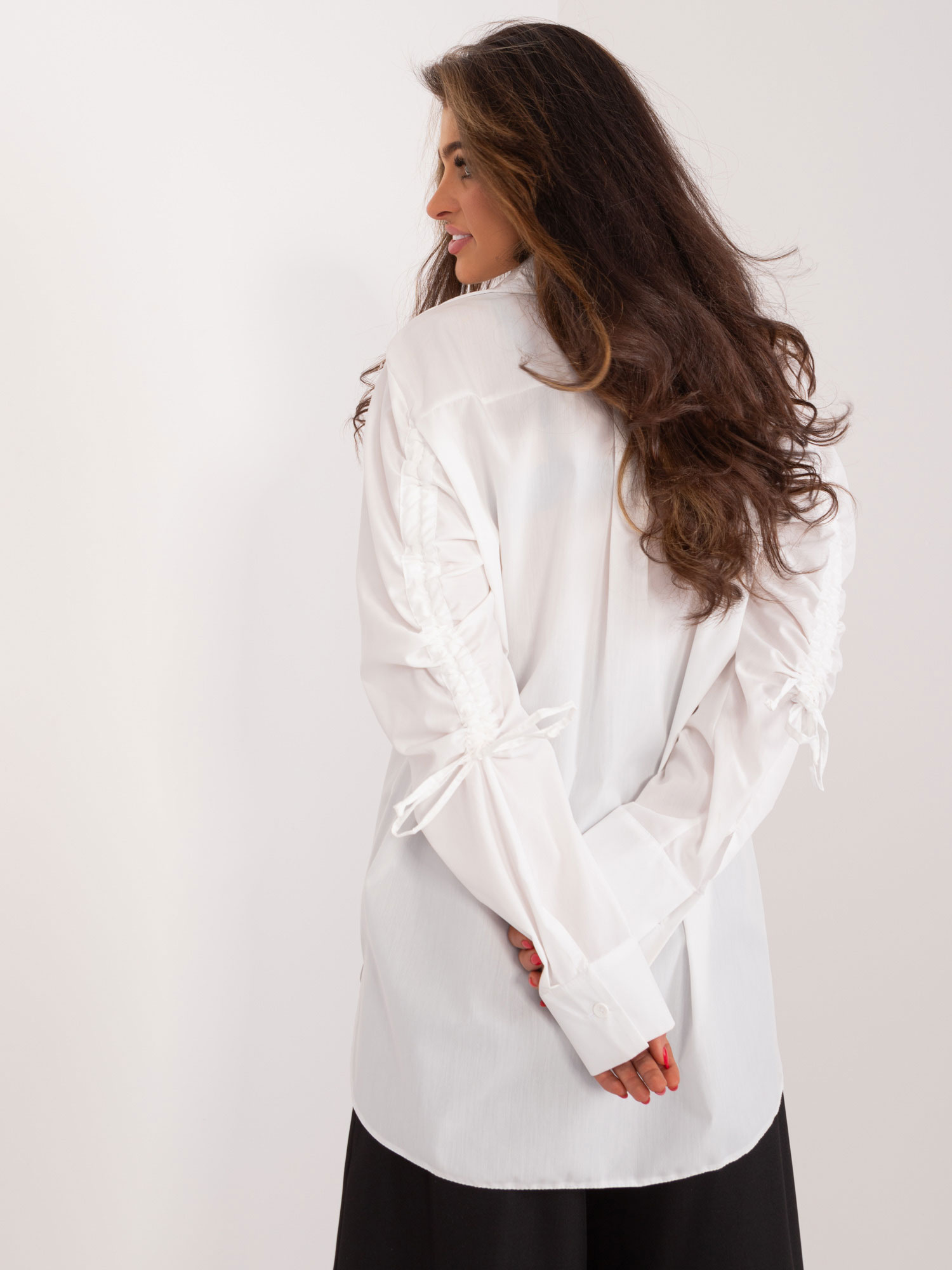 Hurt weiße lange Bluse mit Bündchen an den Ärmeln.