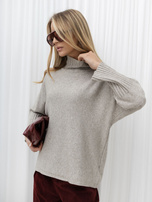 Beige women's turtleneck sweater with wide sleeves.