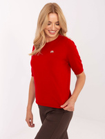 Czerwony damski sweter z broszką w kształcie M