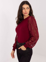 Burgundy sweater made of ribbed knit.