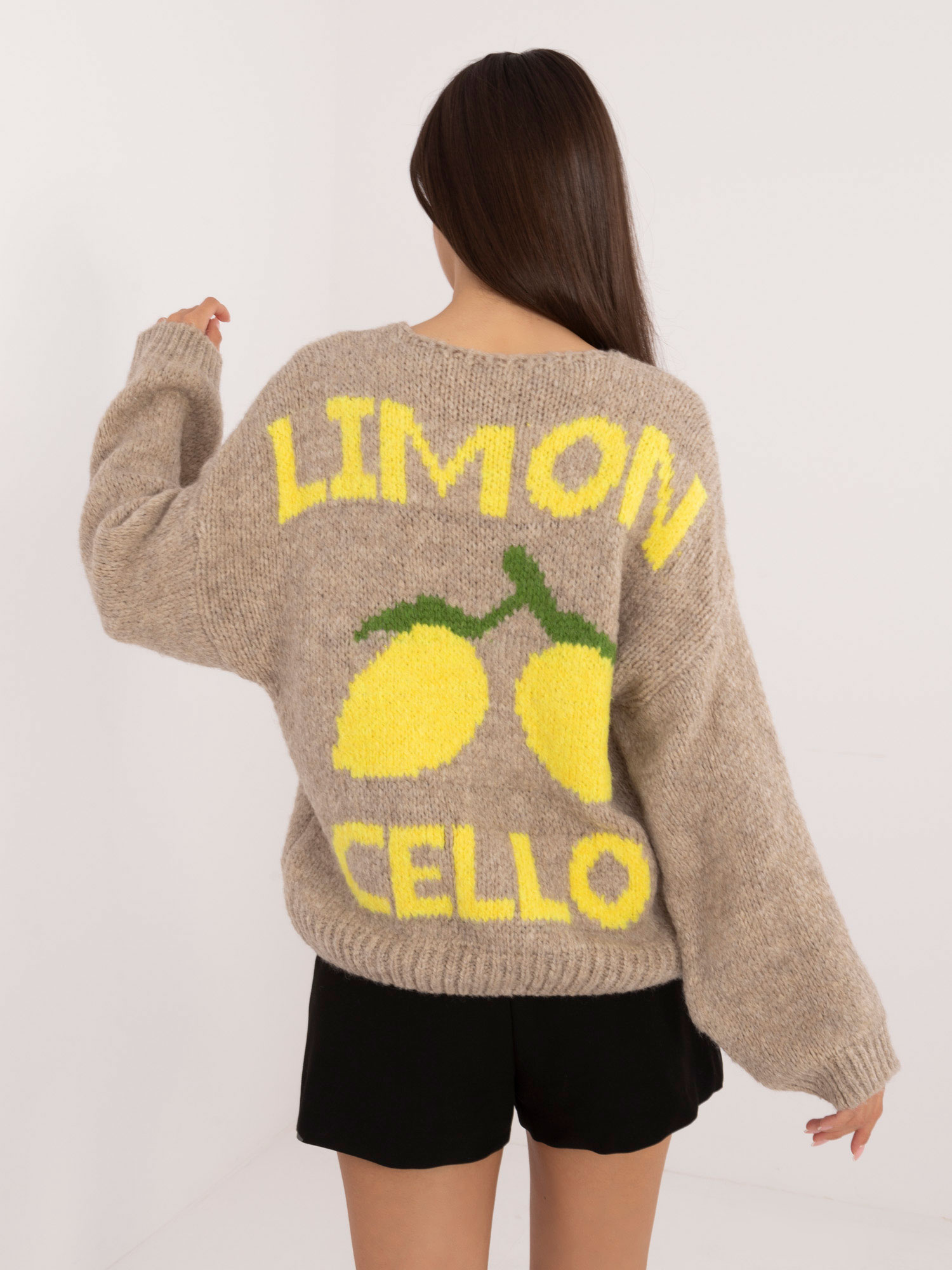 Beige zip-up sweater with a print on the back.
