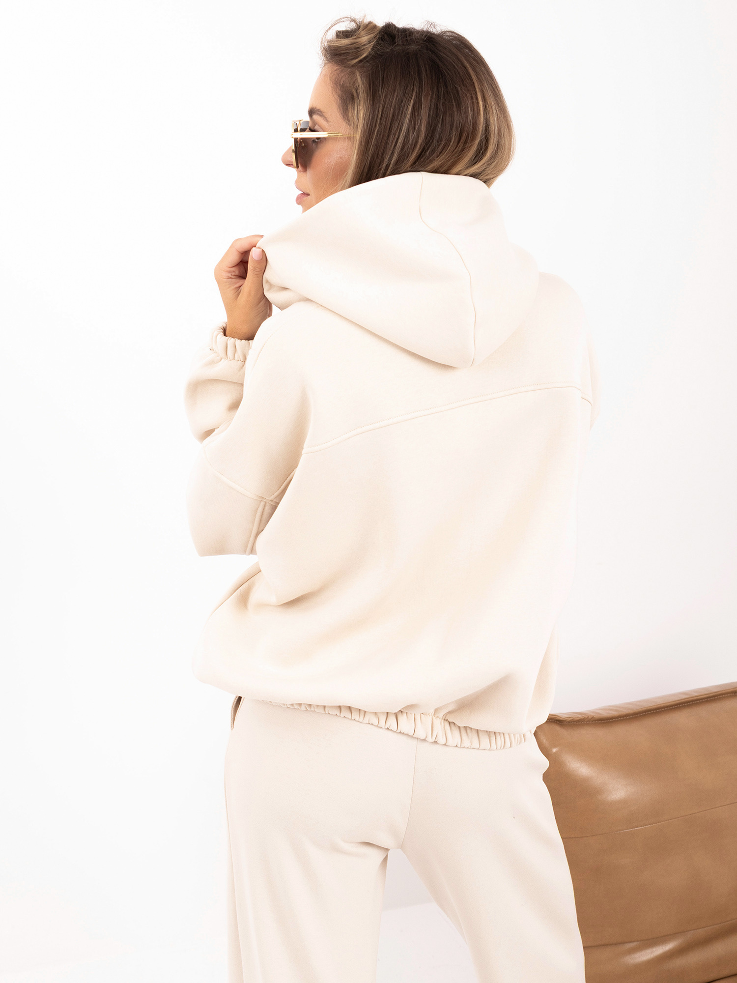 Light beige zip-up sweatshirt with a bomber-style bottom.