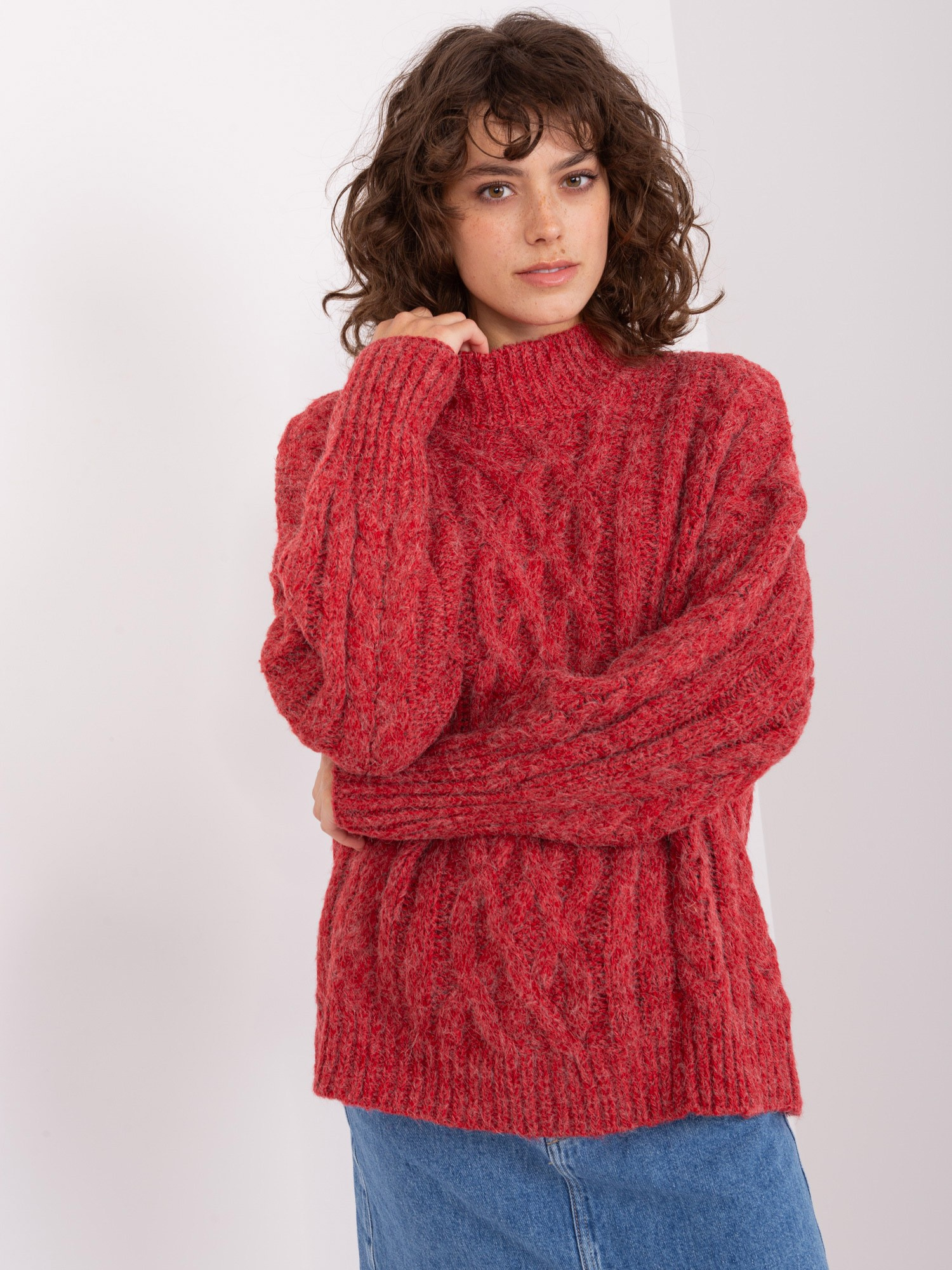 Dunkelroter Pullover mit Zöpfen und Bündchen.