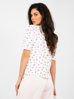 White blouse with gathers on the shoulders.