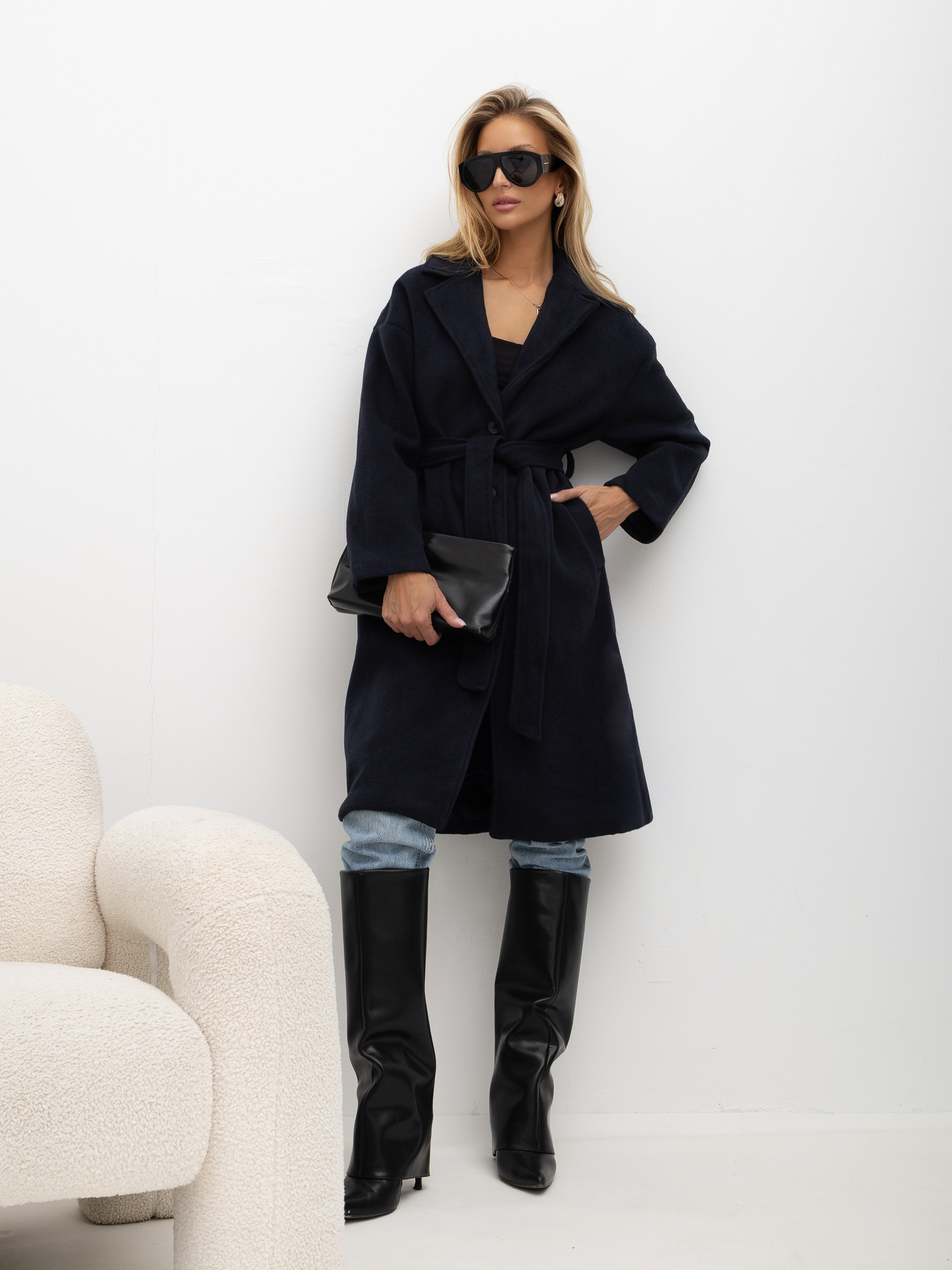Navy women's coat with a tied belt.