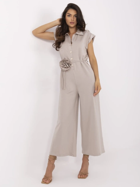 Beżowy damski kombinezon z kwiatową broszką