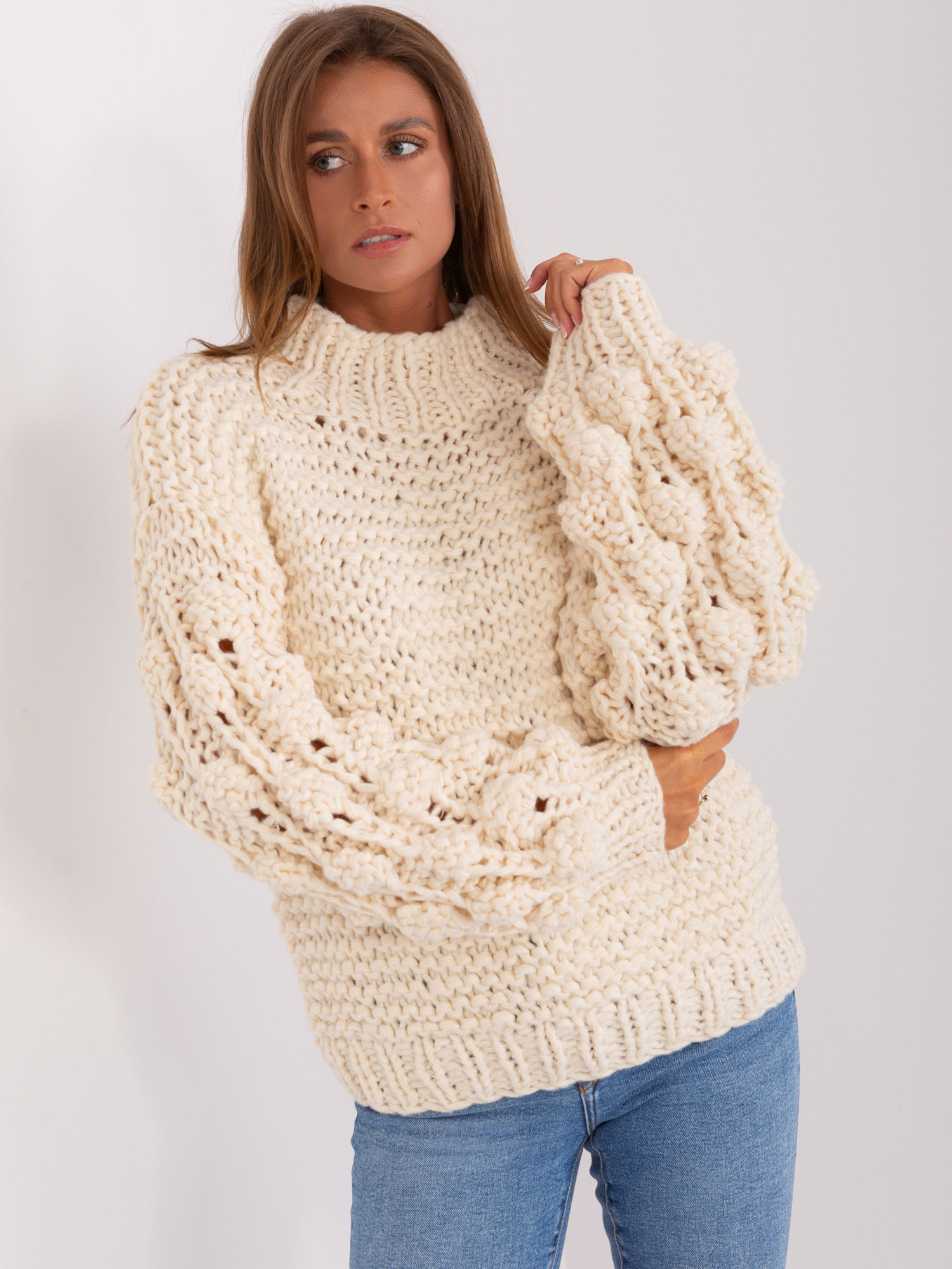 Jasnobeżowy sweter oversize z grubym splotem