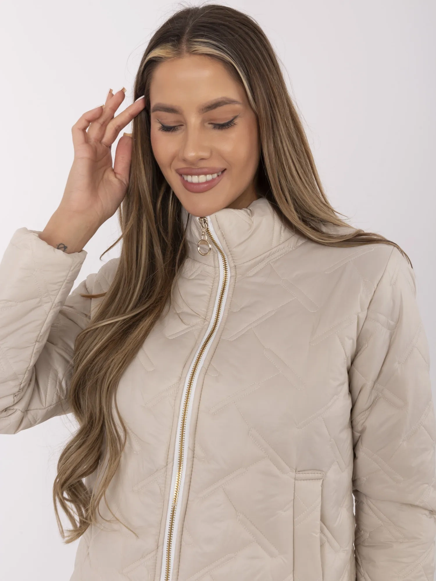 Beige gesteppte Damenjacke mit Stehkragen.