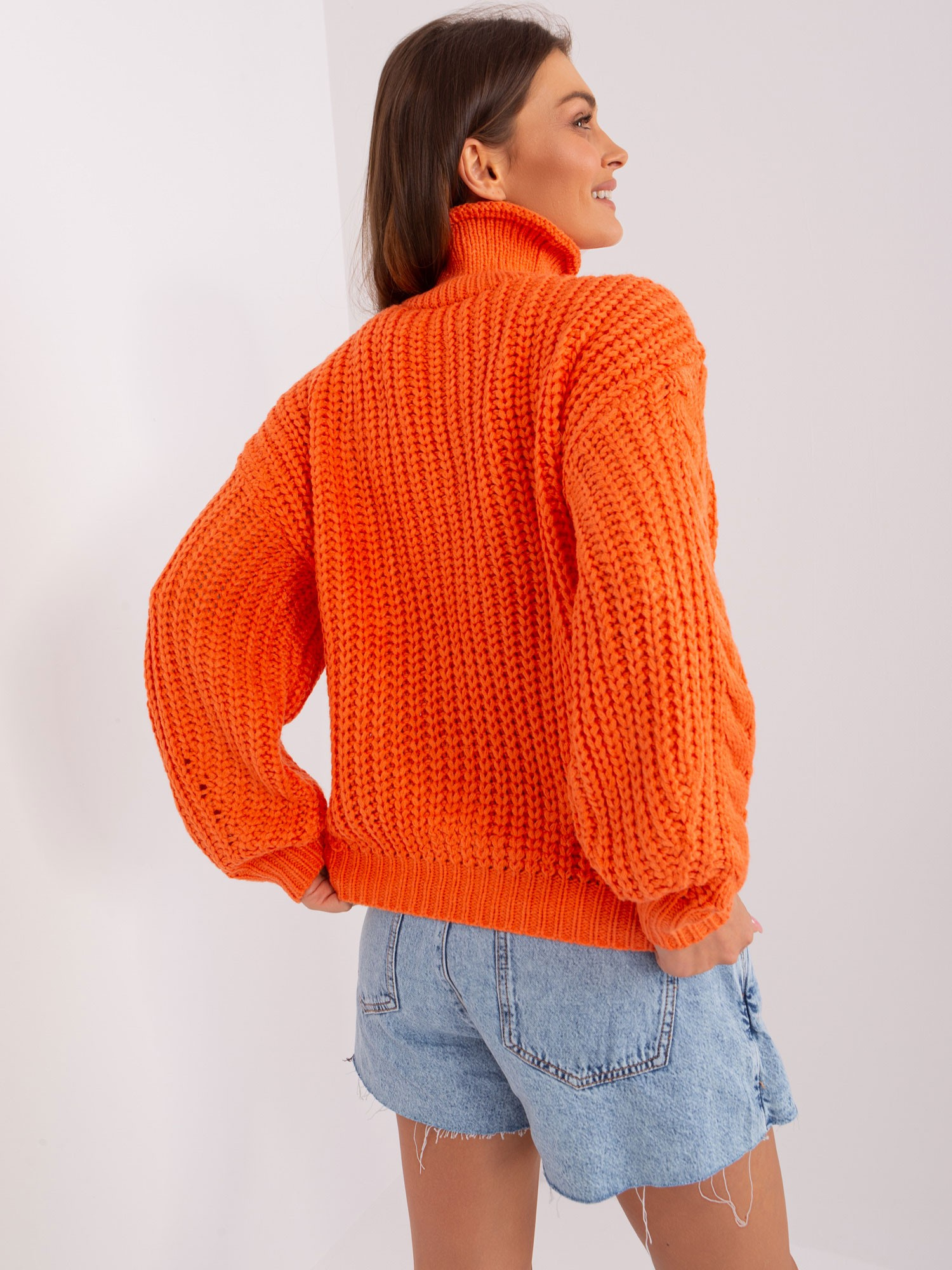 Pomarańczowy sweter oversize z warkoczami