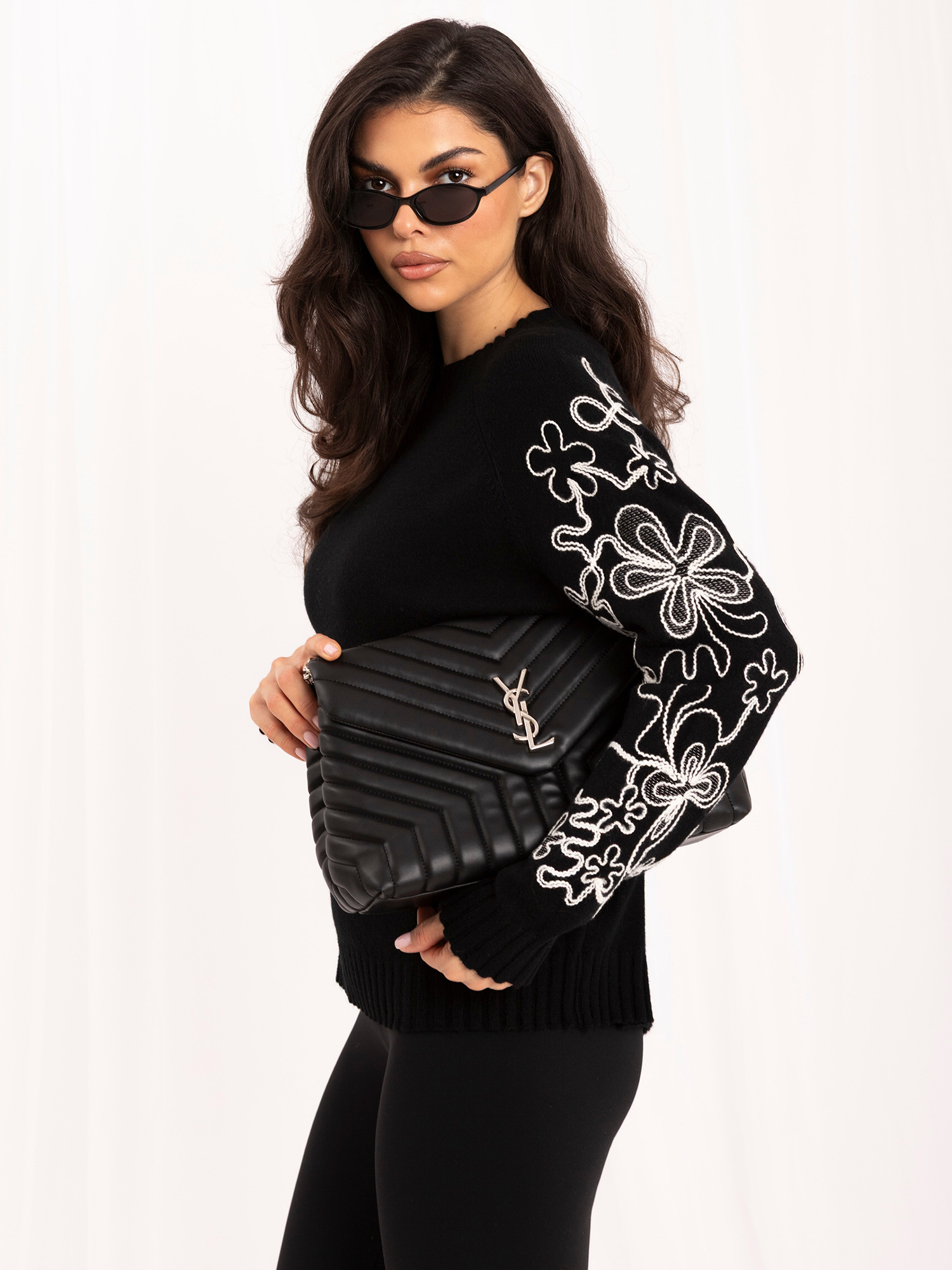 Schwarzer Damenpullover mit kontrastierender Stickerei.