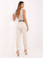 Světlé béžové teplákové kalhoty s ozdobnými knoflíky.