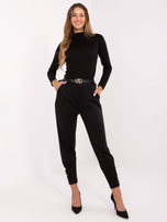 Black sweatpants with decorative buttons.