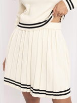 Helle beige Strickanzug mit plissiertem Minirock.