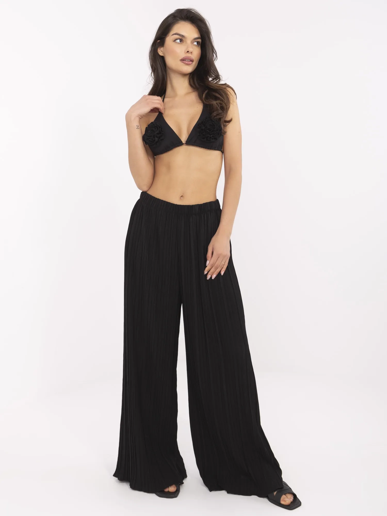 Schwarze strukturierte Hose mit weitem Bein.