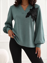 Dunkelviolette elegante Bluse mit Blumenapplikation.