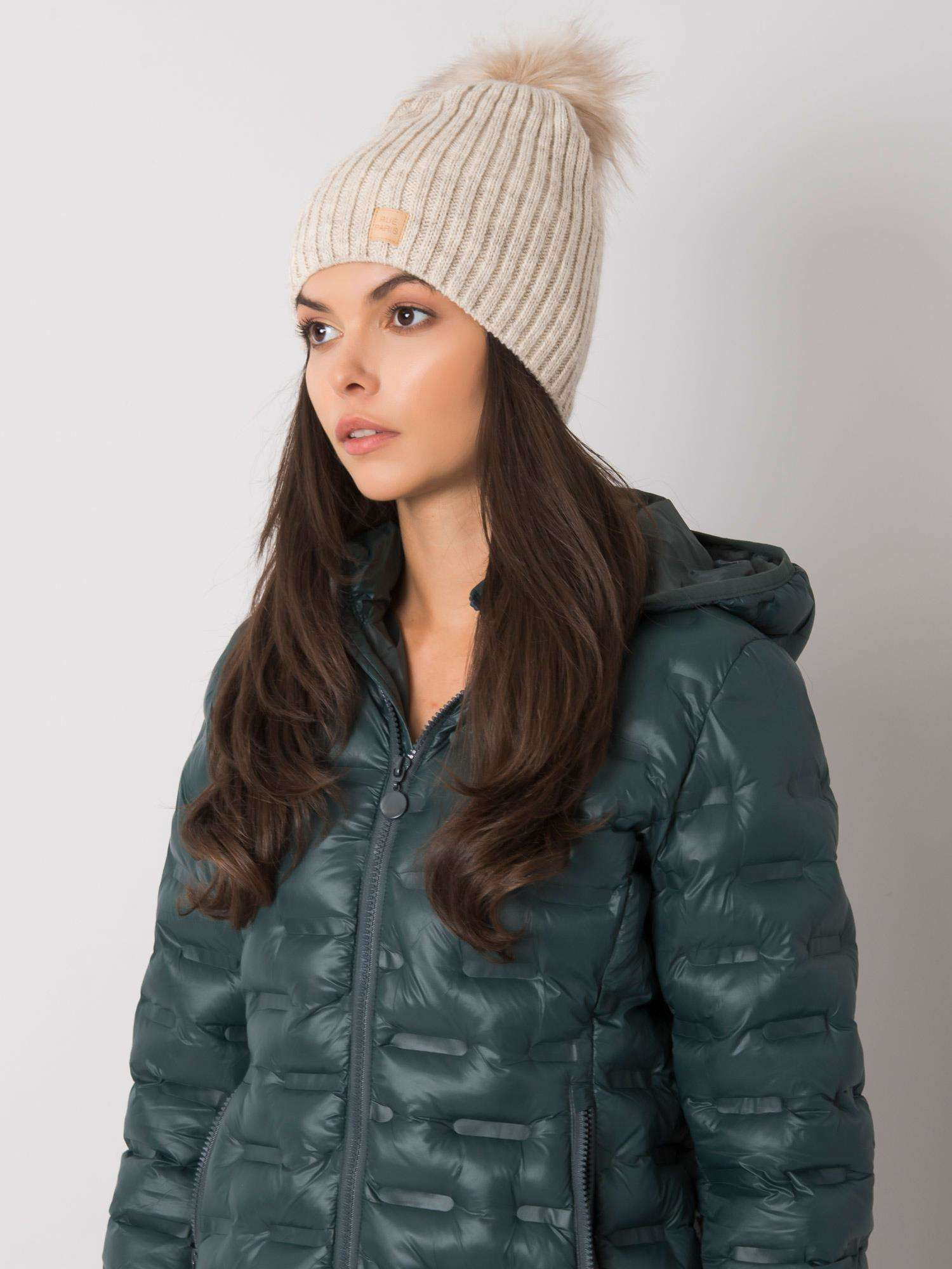 Beige gefütterte Damenmütze mit Pompon.