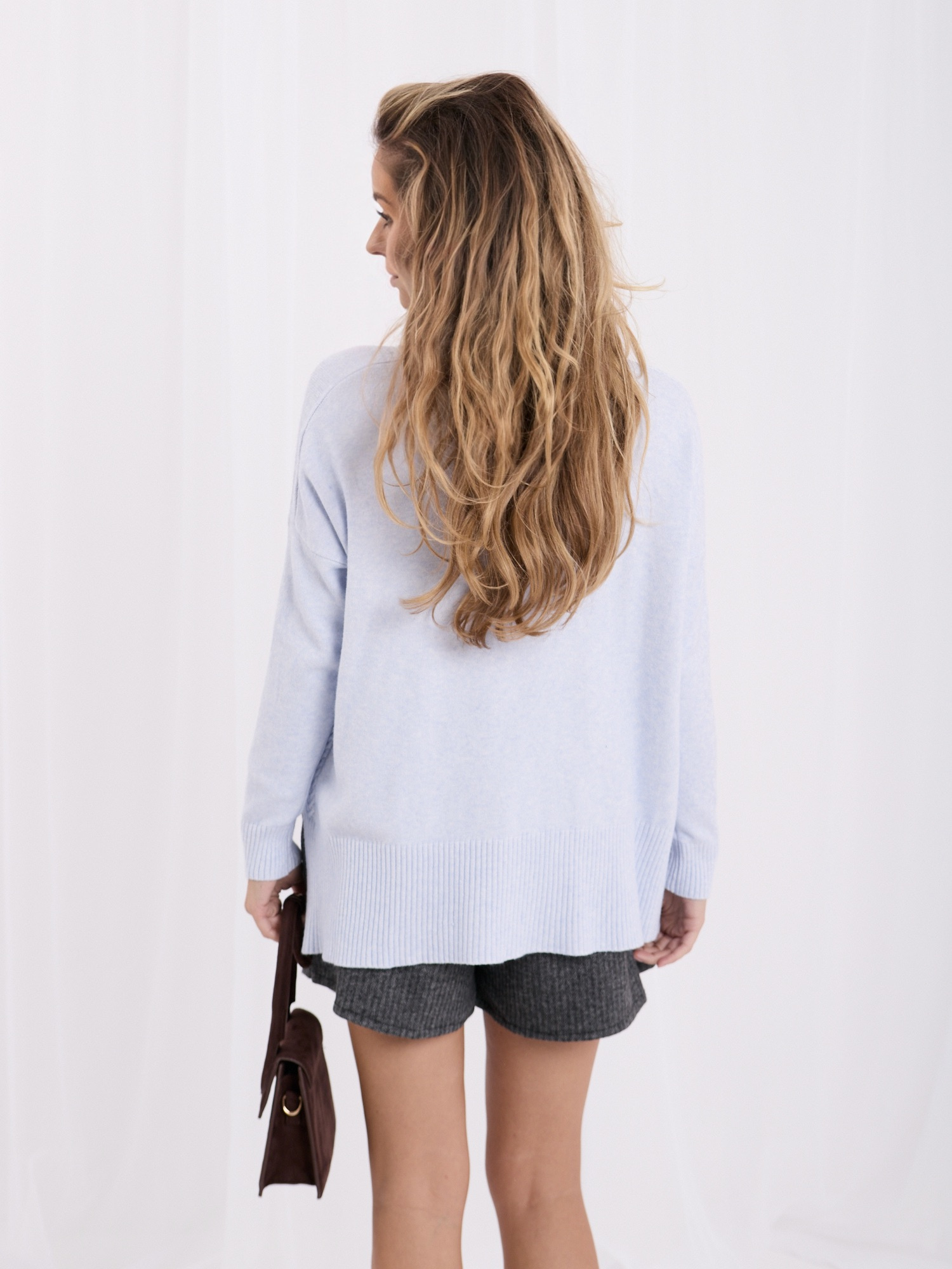 Helles Blau Oversize-Pullover mit längerem Rücken.
