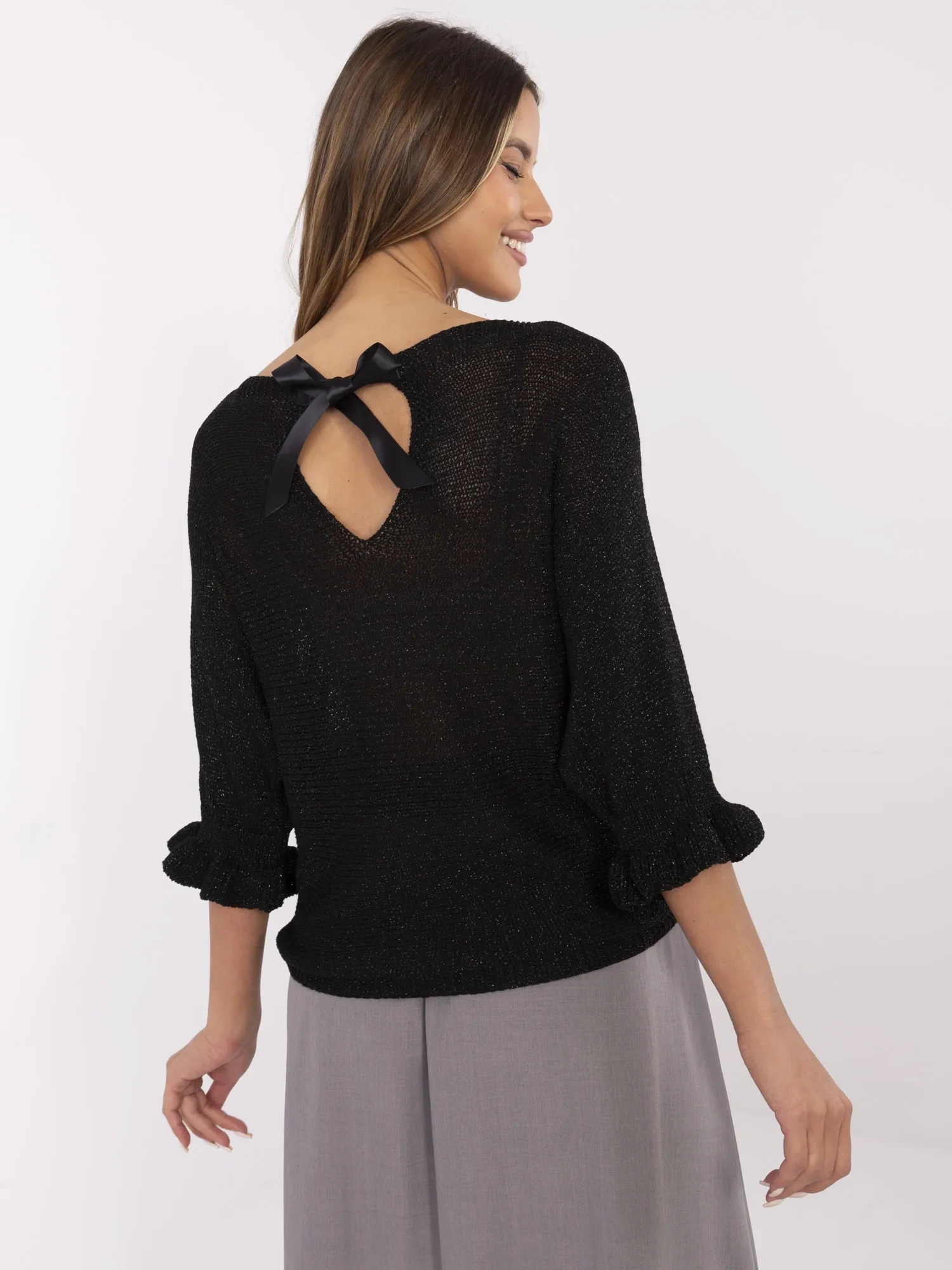 Schwarzer Oversize-Pullover mit einer Schleife auf dem Rücken.