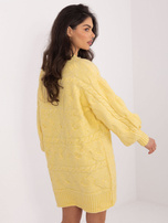 Light yellow sweater dress with braids.