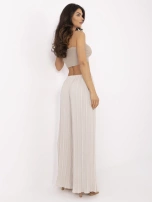 Beige wide trousers made of textured fabric.
