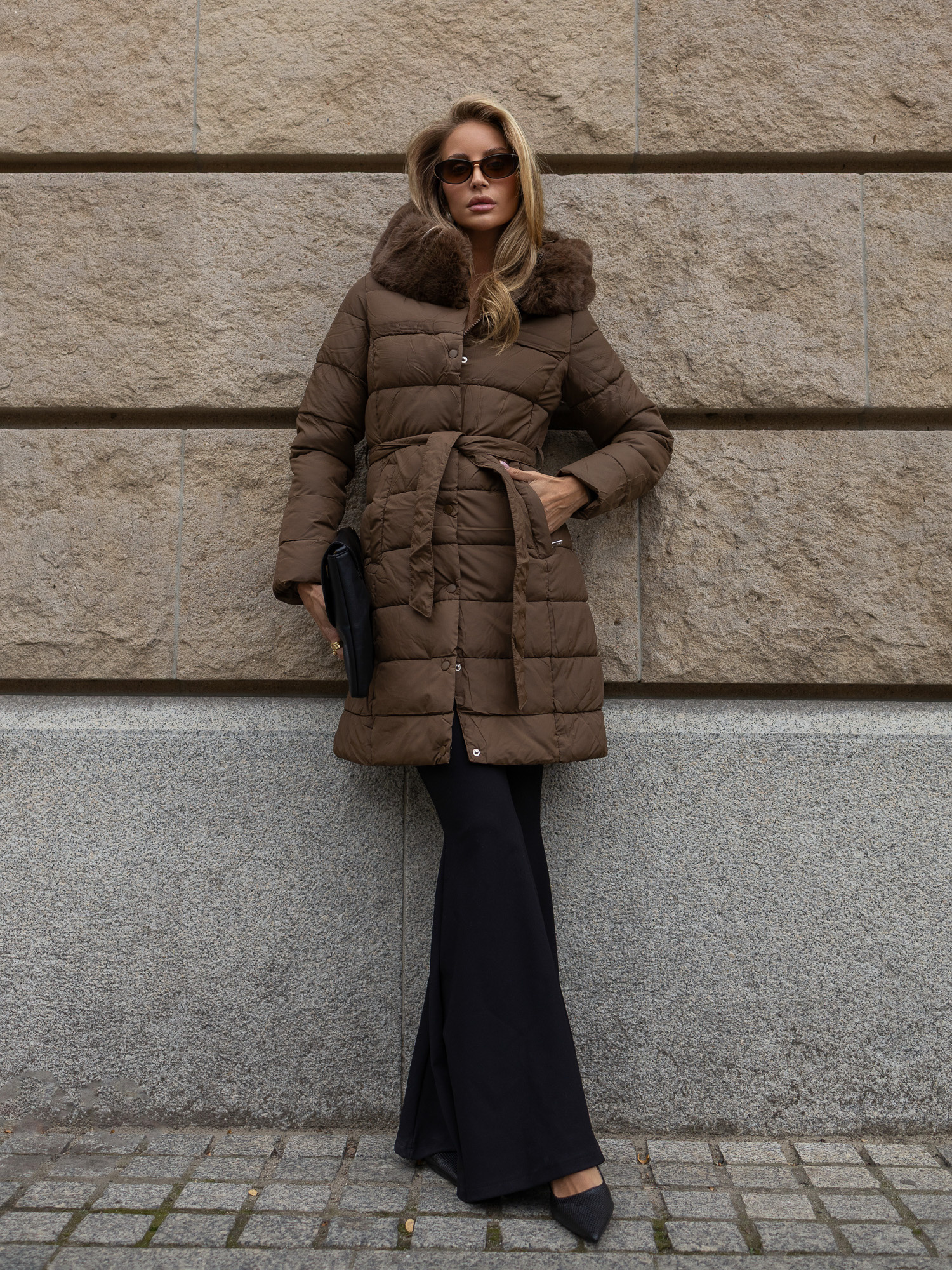 Brown quilted winter jacket with a tied belt.