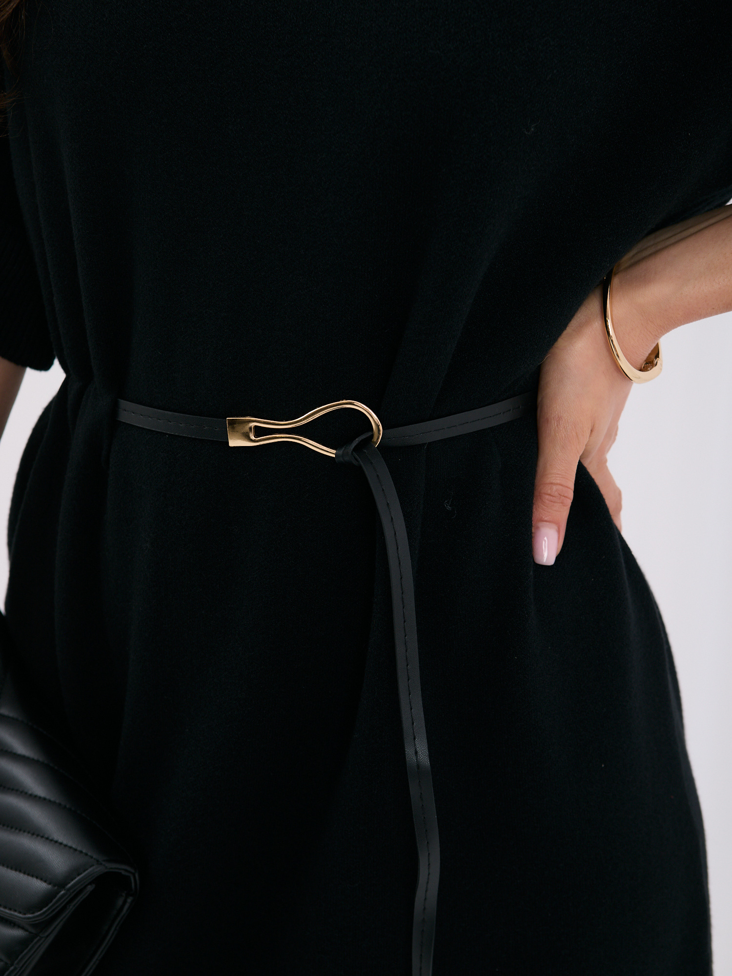 Čierna pletená šaty s ozdobnými gombíkmi na rukávoch.