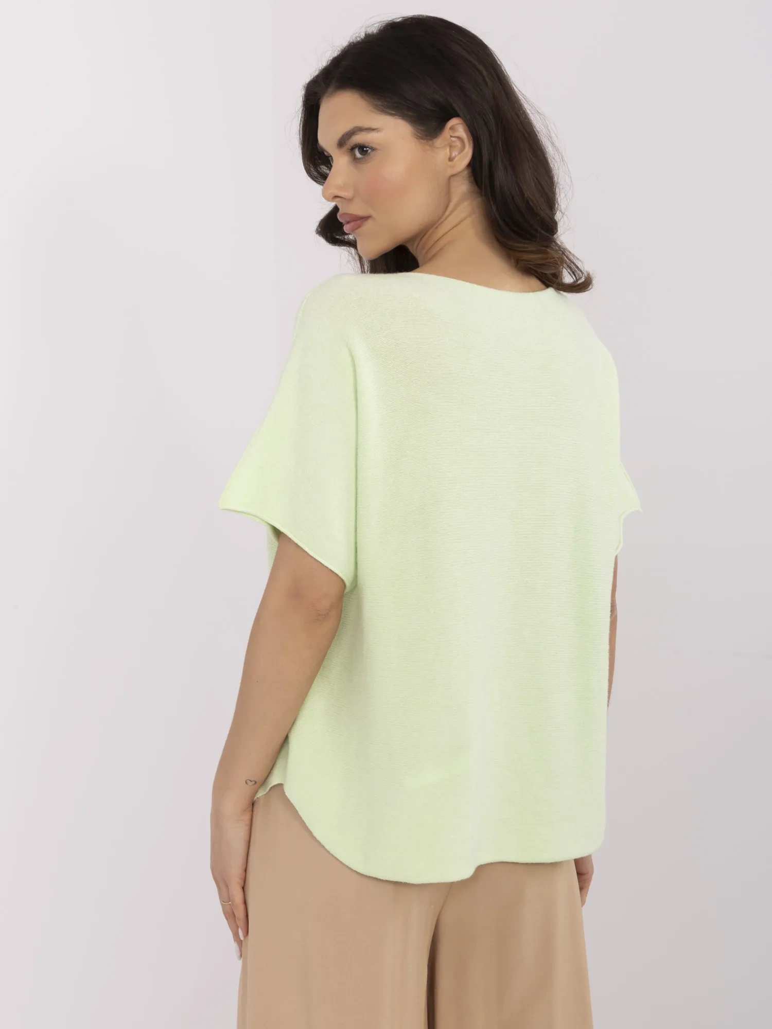 Pistazienfarbener Oversize-Pullover mit kurzen Ärmeln.