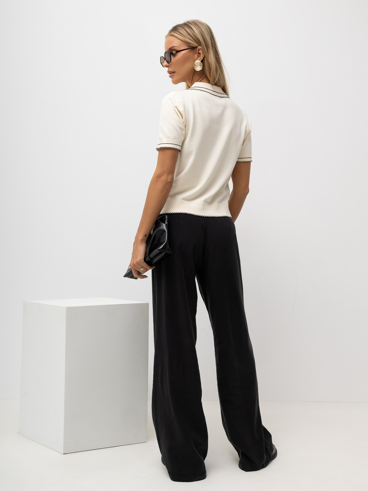 Helle beige Damen-Polo-Pullover mit Knöpfen am Ausschnitt.