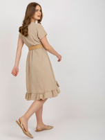 Beige Kleid mit Rüsche und Gürtel.