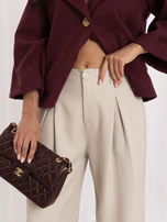 Beige Anzughose mit Falten.