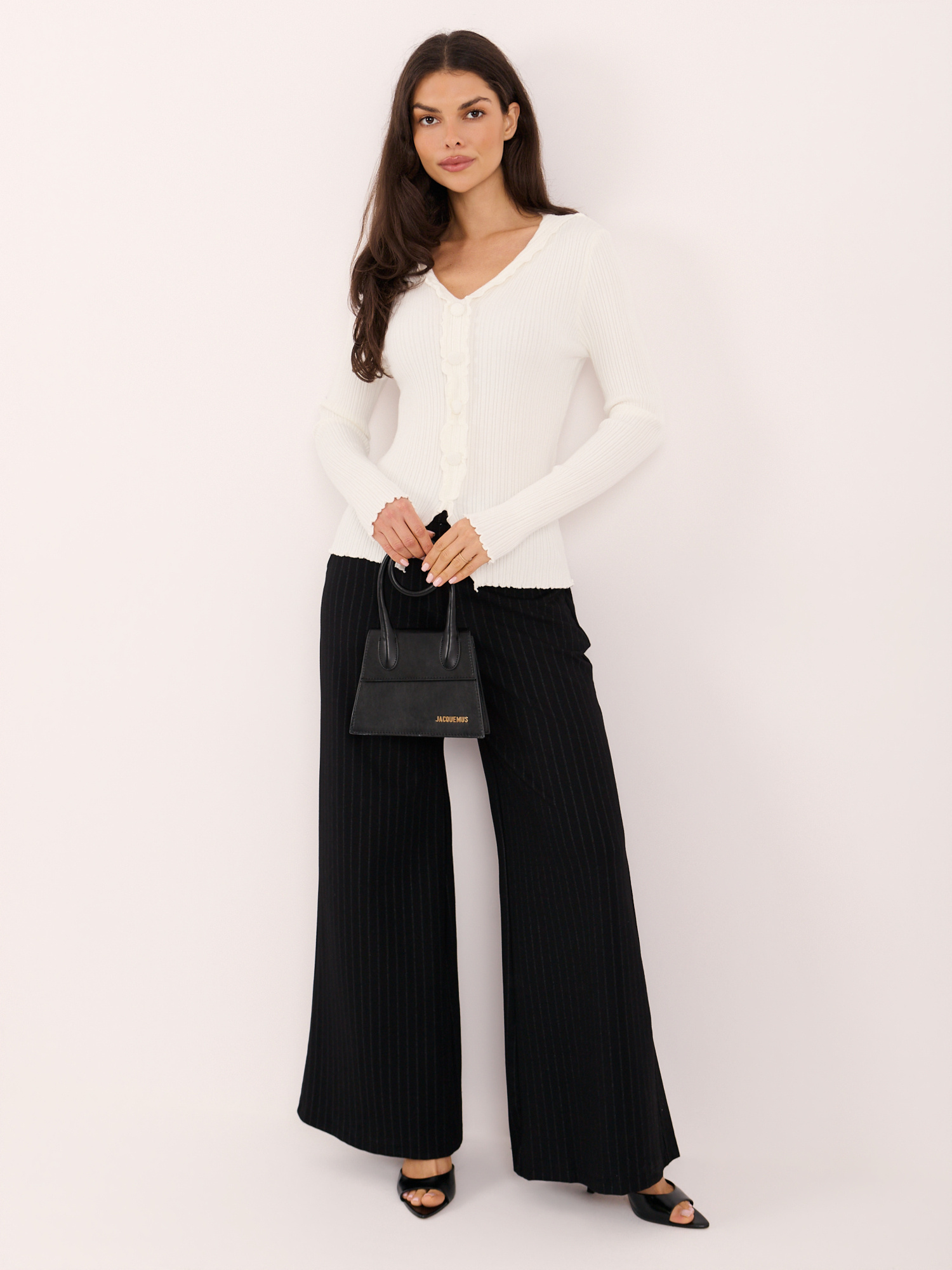 Ecru ribbed sweater with decorative buttons.