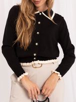 Black zip-up sweater with ruffles.