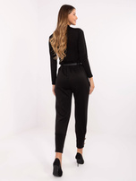 Black sweatpants with decorative buttons.
