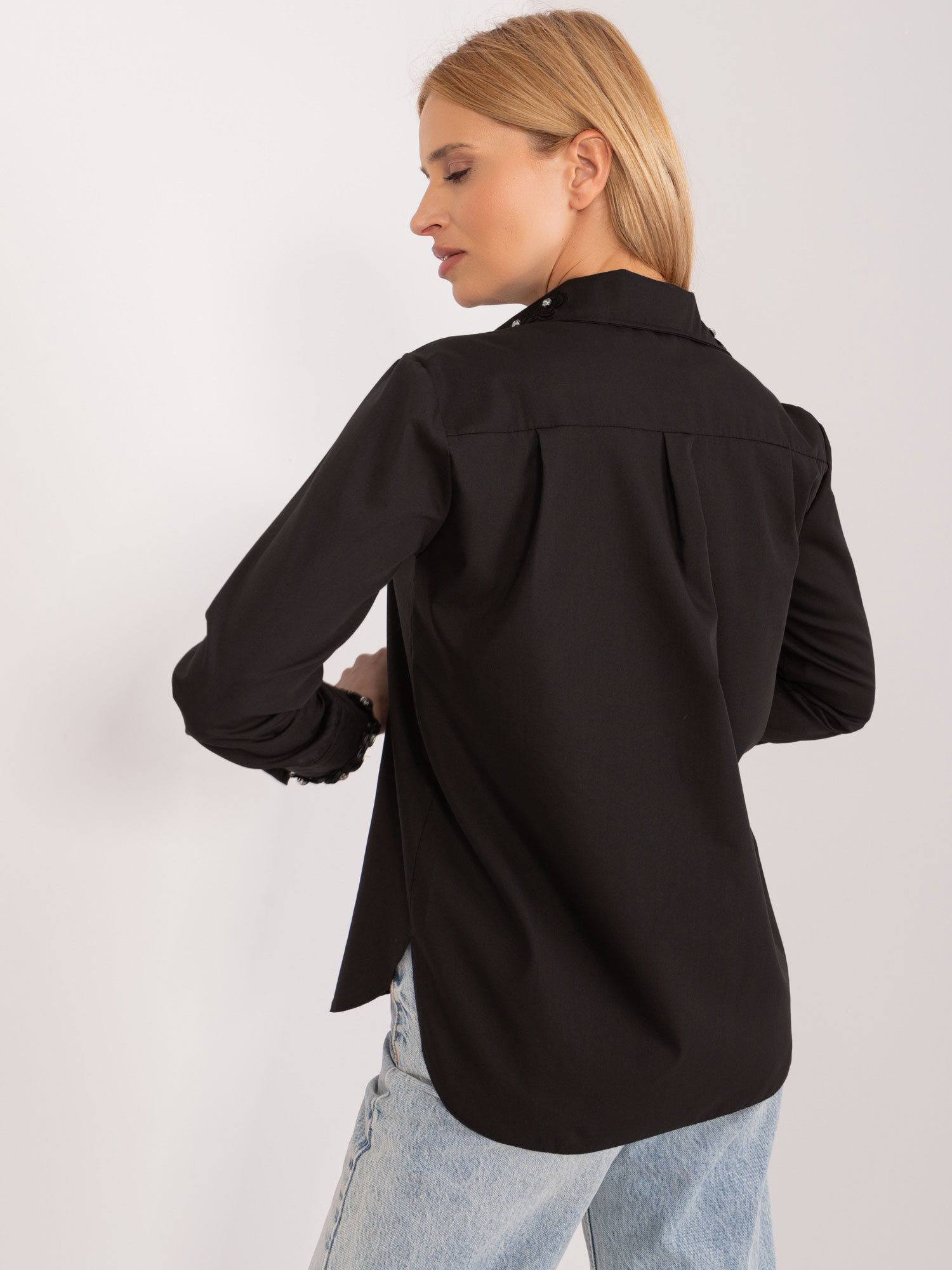 Großhandel Schwarze Damenbluse mit dekorativen Knöpfen.