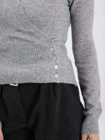 Grauer Wickelsweater mit Knöpfen an der Seite.