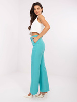 Hurt turquoise fabric pants with a belt.
