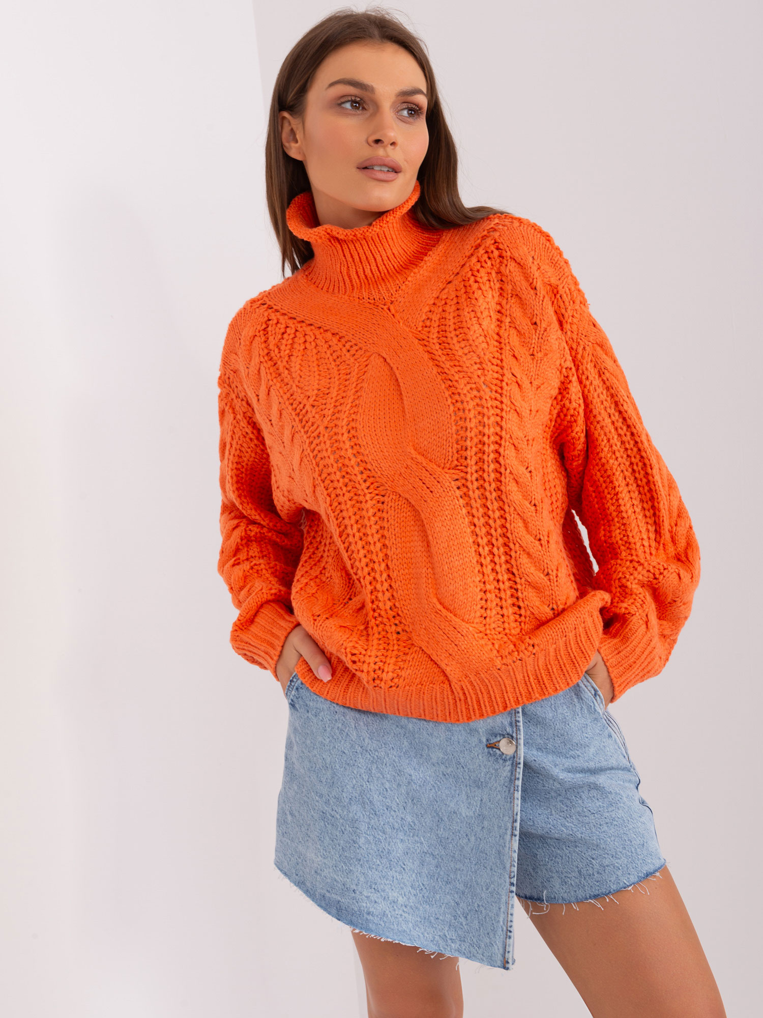 Pomarańczowy sweter oversize z warkoczami