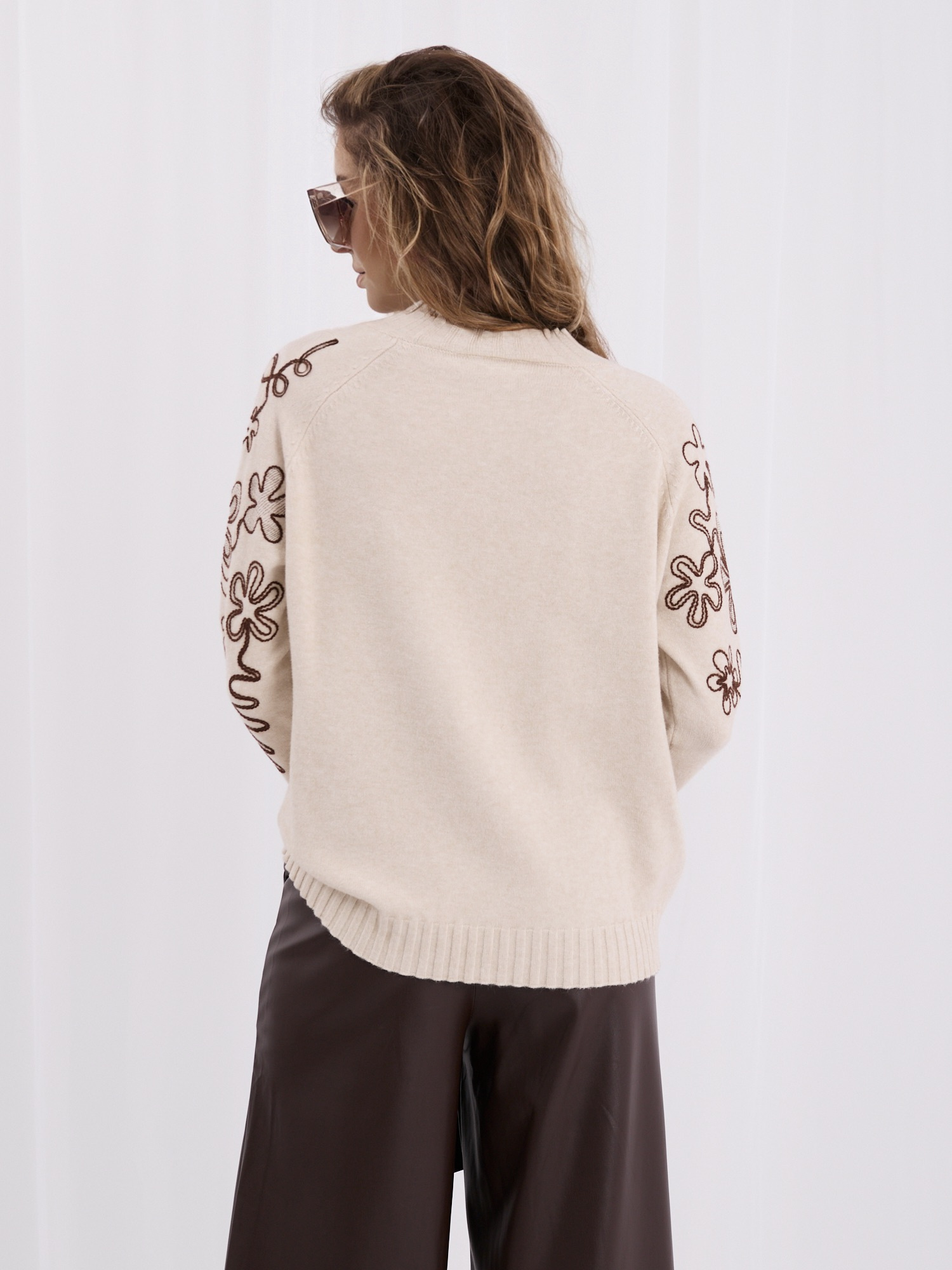 Helle beige Damenpullover mit kontrastierendem Stickerei.