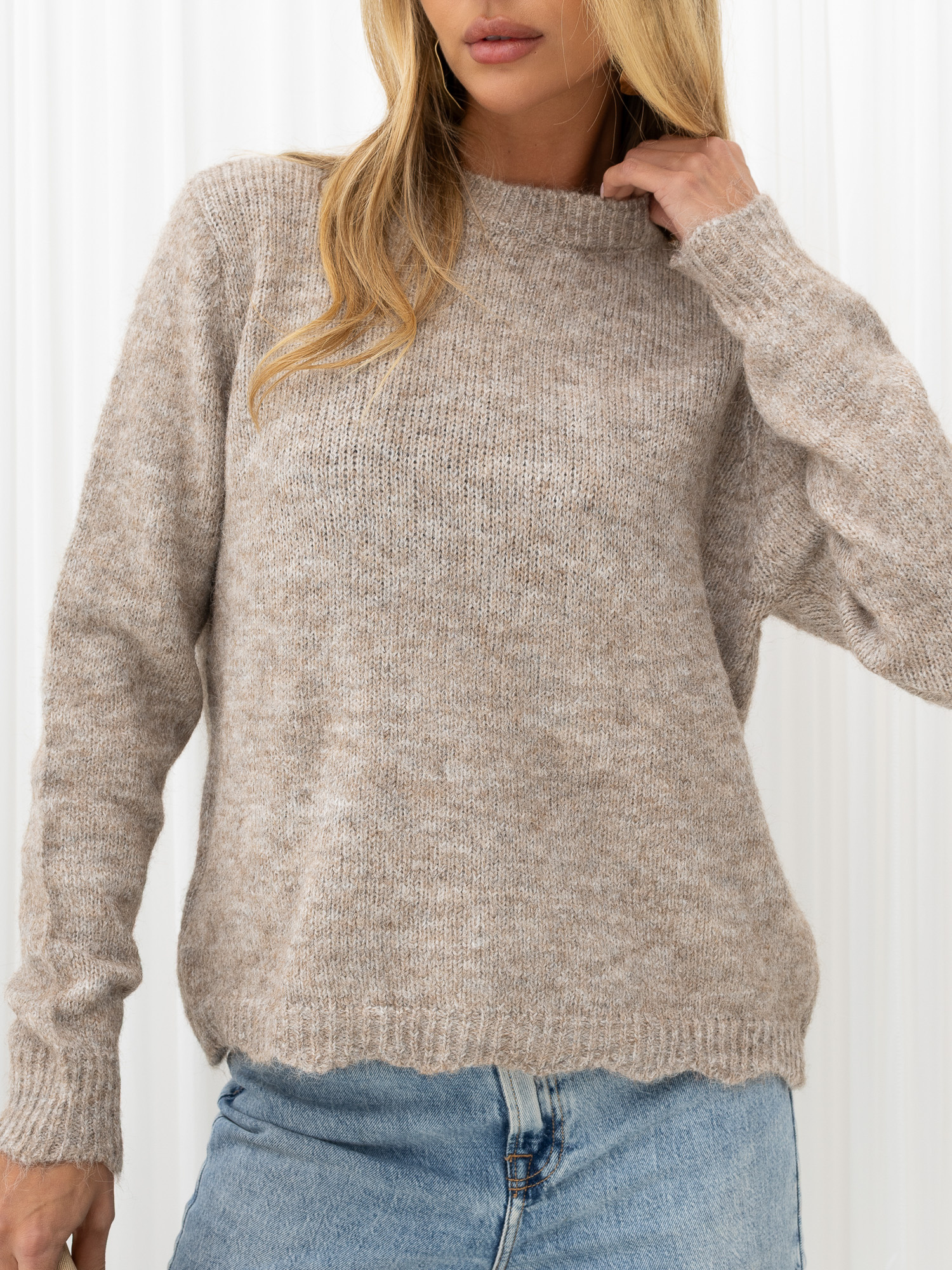 Beige flauschige Strickjacke mit Schmuckknöpfen.
