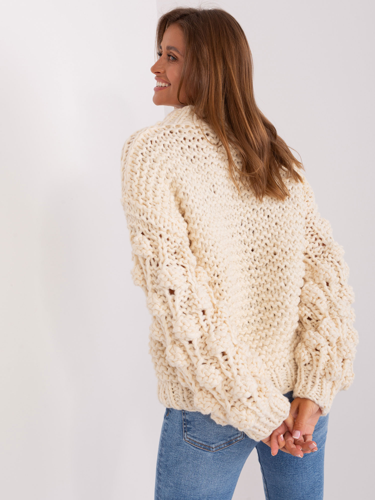 Jasnobeżowy sweter oversize z grubym splotem