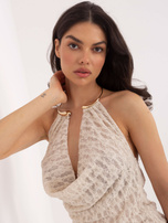 Jasnobeżowy top z ozdobnym naszyjnikiem 