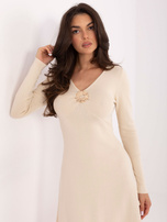 Helle beige Kleid mit dekorativem Element.