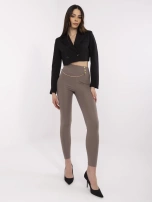 Kaffefarbene Damen-Leggings mit dekorativen Druckknöpfen.