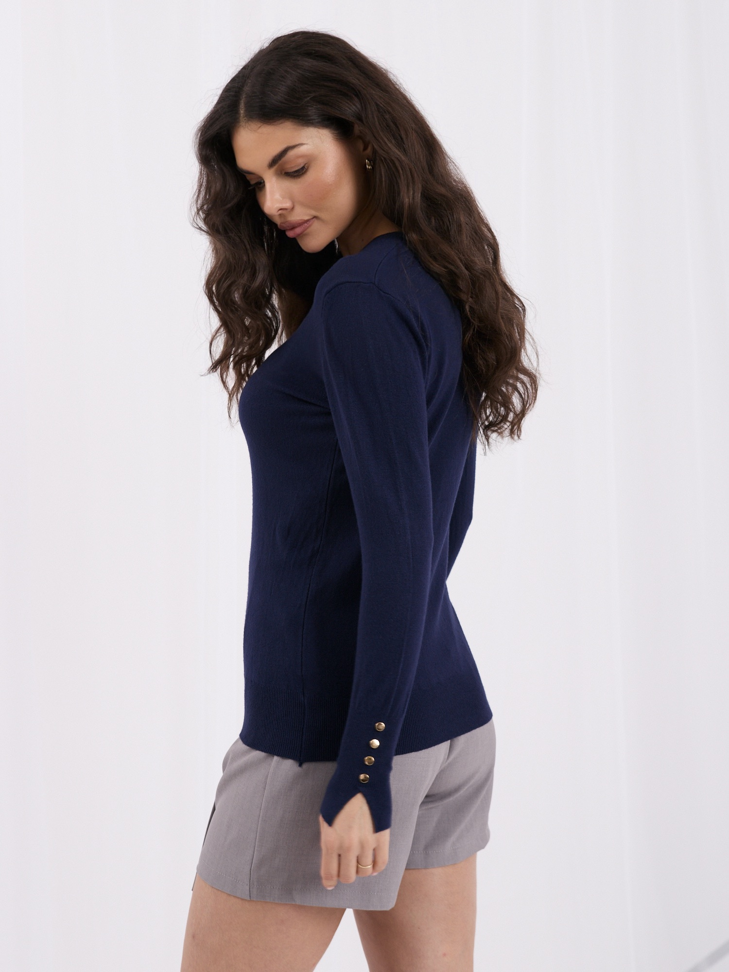 Dunkelblauer Damenpullover mit dekorativen Bündchen.