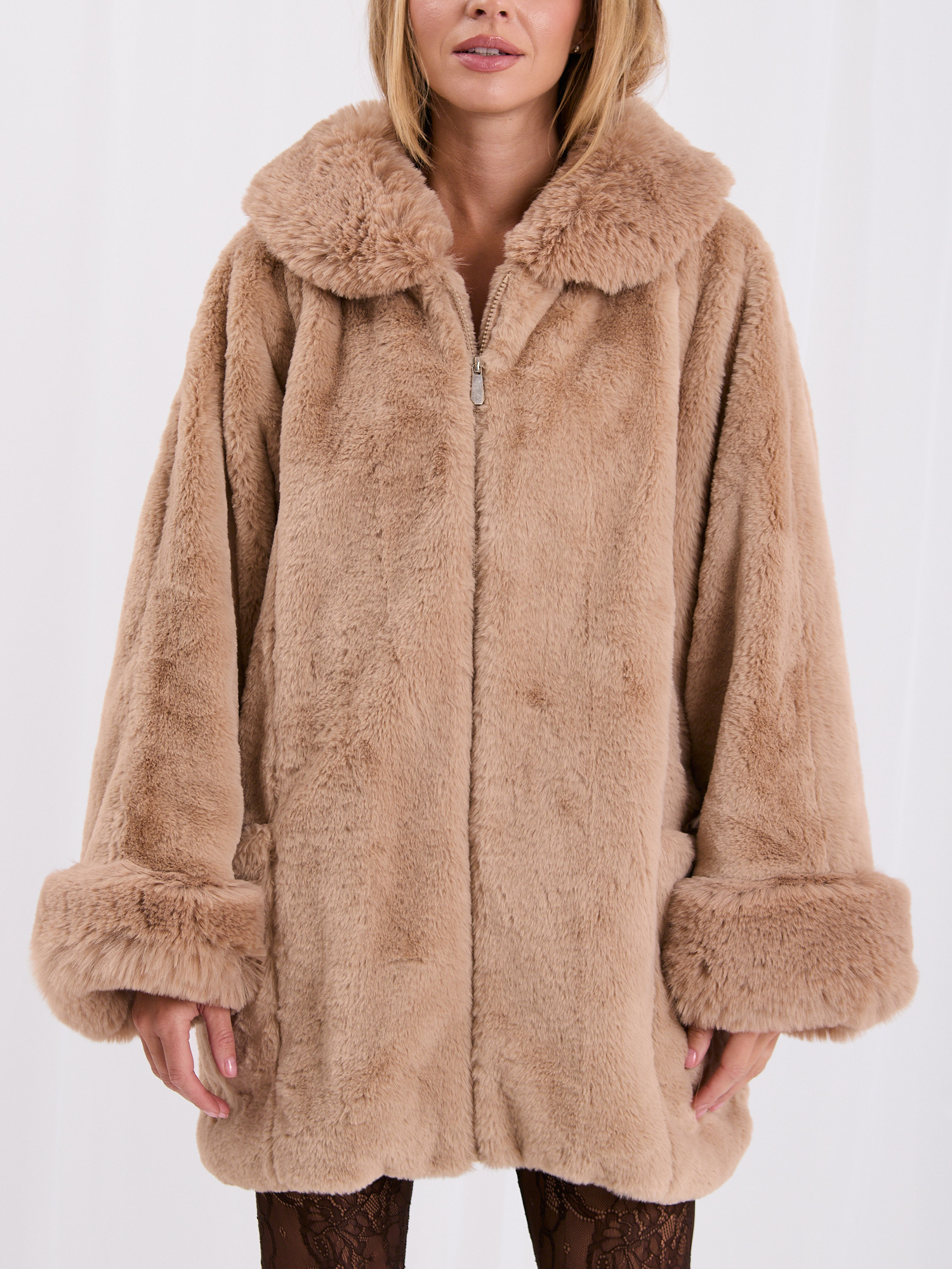 Beige women's fur coat with impressive sleeves.