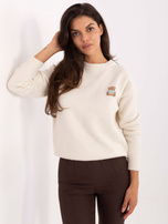 Jasnobeżowy damski sweter z naszywką misia