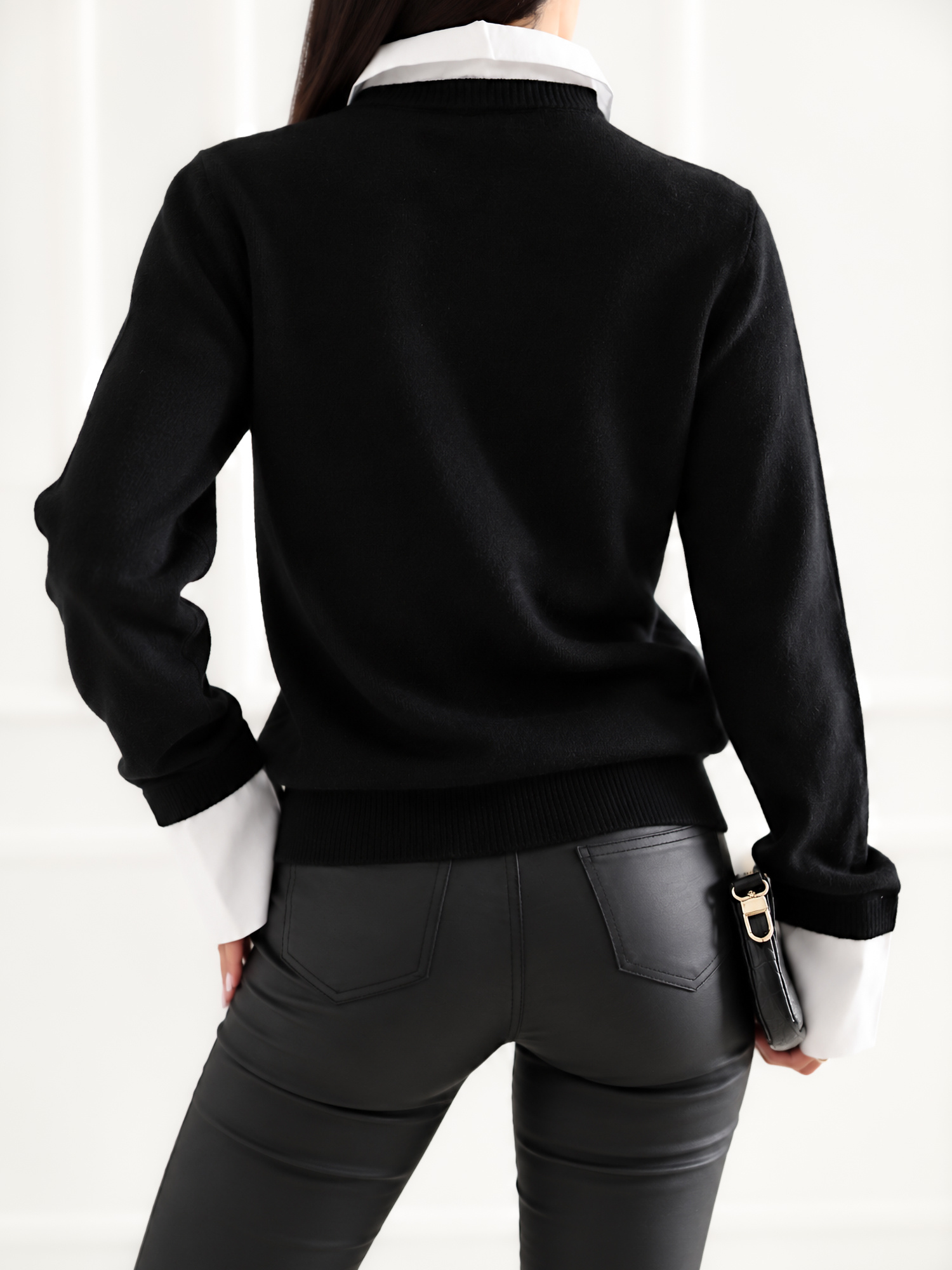 Schwarzer Damenpullover mit Hemdeinsatz.