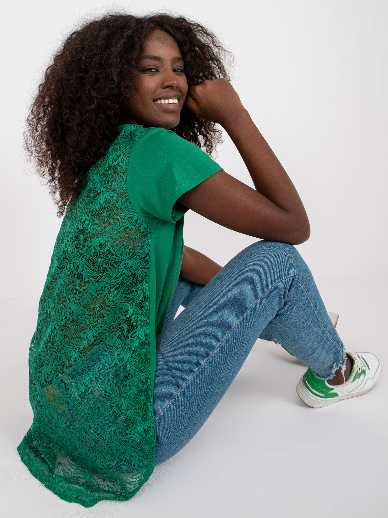Temnozeleno ohlapna bluza z čipkastim hrbtom.